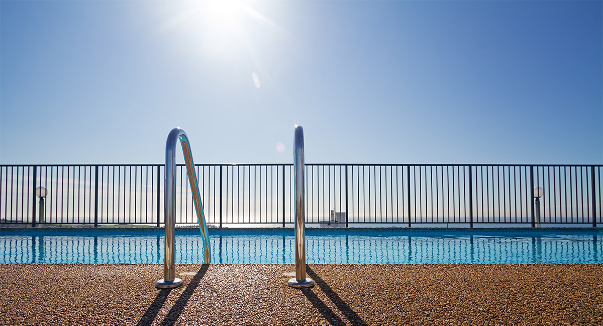 Pool with compliant safety barrier fencing